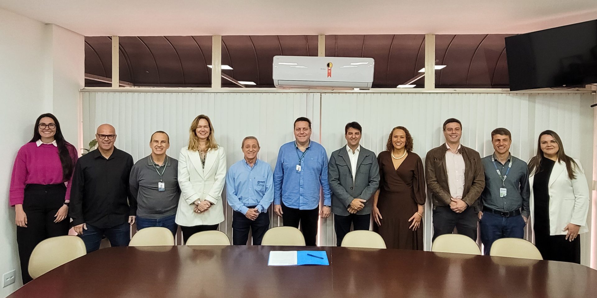 Representantes da Bracell, da Prefeitura de Lençóis Paulista e do Centro Municipal de Formação Profissional posam lado a lado em uma sala de reuniões durante a assinatura de parceria para oferta de cursos gratuitos de formação profissional.