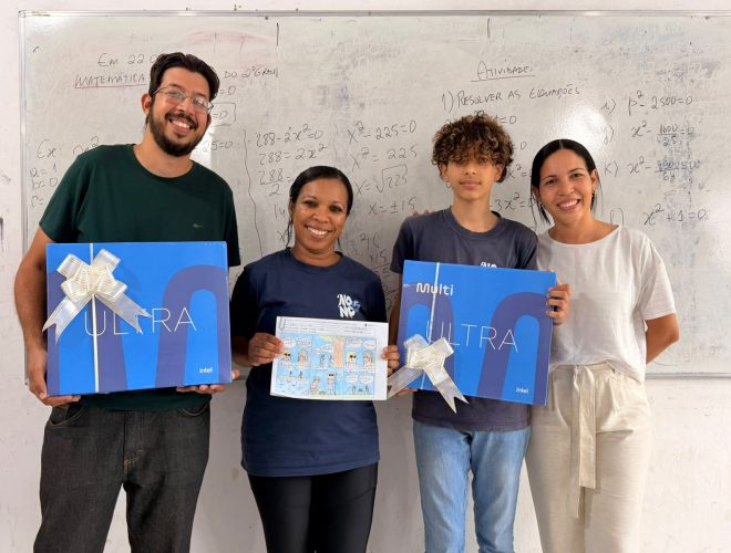 Estudante, profissionais da escola e representante exibem premiações e história em quadrinhos em sala de aula.